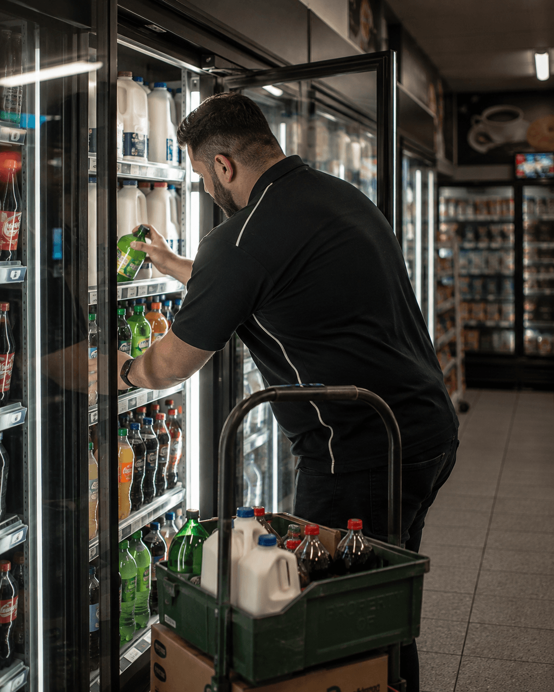 Store owner restocking a convenience store fridge — Ideal Insurance Brokers