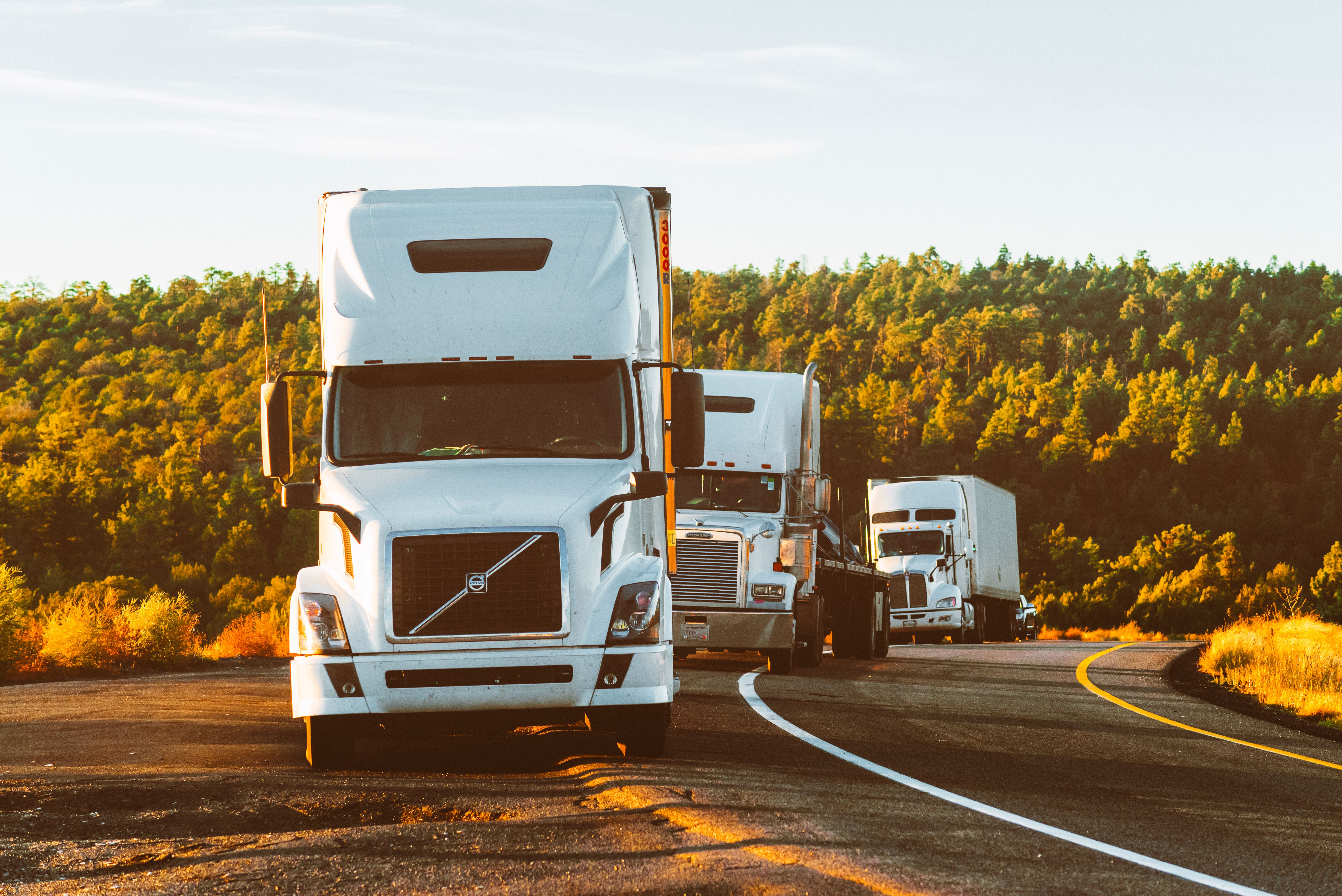 Truck driving on highway at sunset